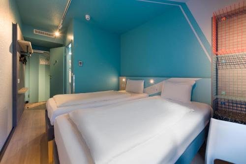 two beds in a room with blue walls at ibis budget Hamburg St Pauli Messe - neu renoviert in Hamburg