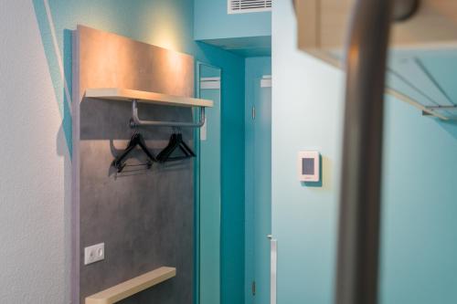 a room with a kitchen with blue walls at ibis budget Hamburg St Pauli Messe - neu renoviert in Hamburg