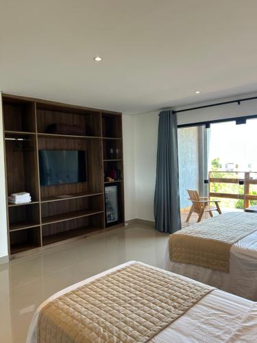 a bedroom with two beds and a flat screen tv at Maluhia Ilhabela 4 in Ilhabela