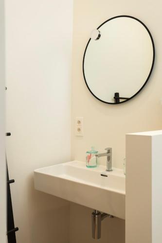 a bathroom with a sink and a mirror on the wall at NOX Logies, vakantiewoning en polyvalente ruimte in Grimbergen