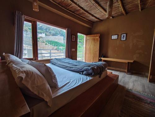 a bed in a room with a large window at Hoongla Inn - Homestay in Lumla Tawang in Kāmbāng