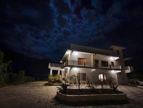 a white house at night with a dark sky at Hoongla Inn - Homestay in Lumla Tawang in Kāmbāng