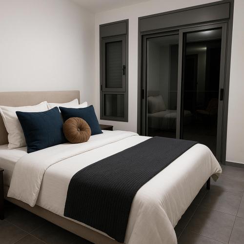 a bedroom with a large bed with a black and white blanket at דירת נופש באכזיב על הים in Nahariyya