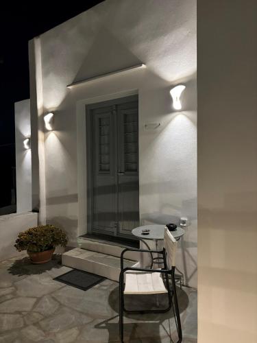 a white room with a chair and a table at Cycladic Lodge Sifnos in Apollonia