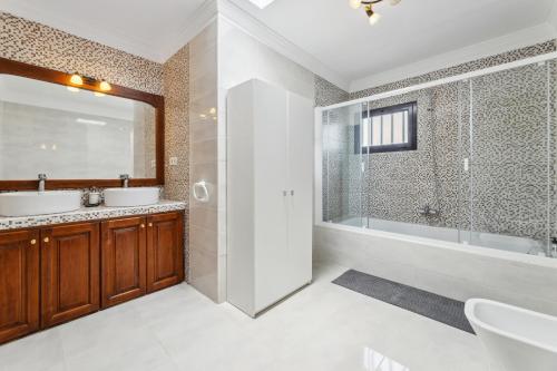 ein Badezimmer mit Badewanne, Waschbecken und Dusche in der Unterkunft Villa dona Isidora - VipVipVillas in Teguise