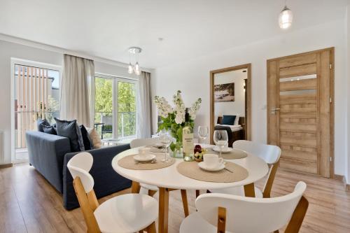 a living room with a table and chairs and a couch at Casa Baia BlueApart Hel in Hel