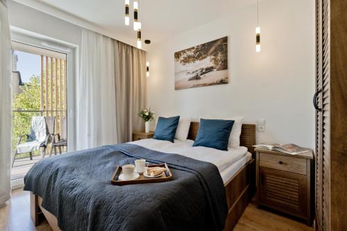 a bedroom with a bed with a tray of food on it at Casa Baia BlueApart Hel in Hel