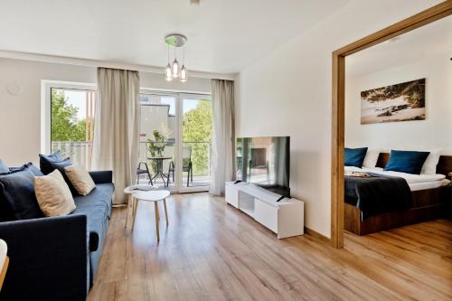 a living room with a couch and a bed and a mirror at Casa Baia BlueApart Hel in Hel