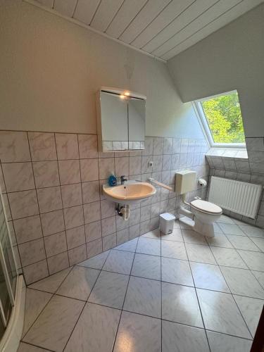 a bathroom with a sink and a toilet at Motel auf der Alm in Soltau