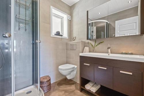 Un baño con inodoro, lavabo y ducha. en Higly rated superhost in citycenter, en Tønsberg