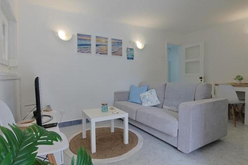 a living room with a couch and a table at Maria's House in Costa da Caparica