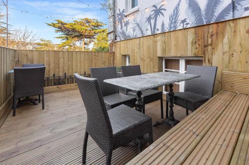a patio with a table and chairs on a wooden deck at Quirky & Wonky Inn - 4 BD in Brighton & Hove
