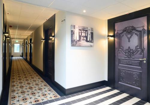 a hallway with a black door and a tiled floor at Landgoed Huize Bergen Den Bosch - Vught in Den Bosch