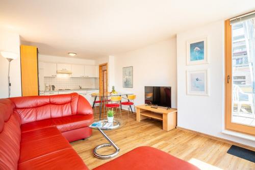 a living room with a red couch and a television at Haus Zander in Heringsdorf