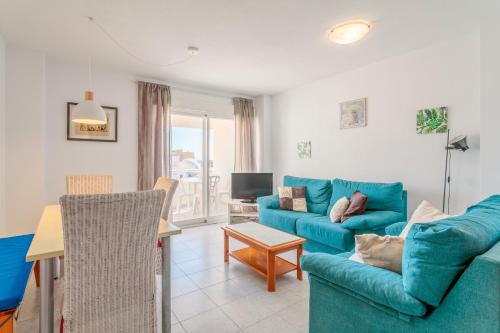 a living room with a blue couch and a table at Morasol in El Campello