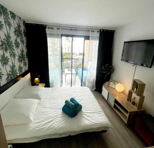 - une chambre avec un lit blanc et une serviette bleue dans l'établissement Sea view La Palme d'Azur apartment steps away from the beach and perfect for holidays & business trips, à Cannes