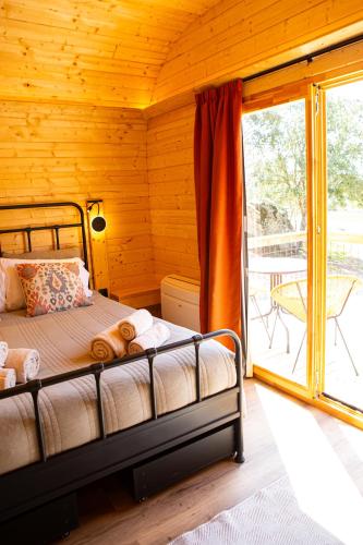 a bedroom with a bed and a balcony at Quinta do Prado Verde in Vilar Formoso