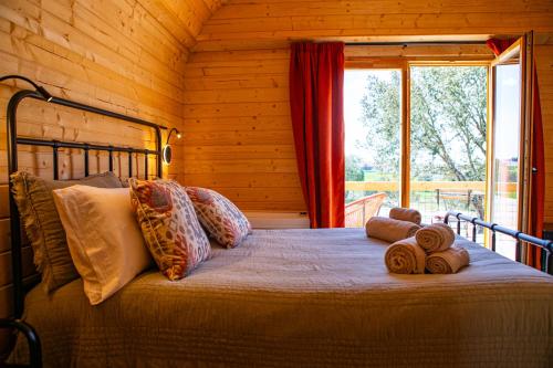 a bed in a log cabin with a window at Quinta do Prado Verde in Vilar Formoso
