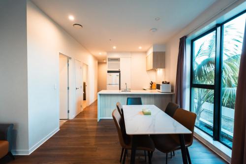 a kitchen and dining room with a table and chairs at The Edgerley Suites in Auckland