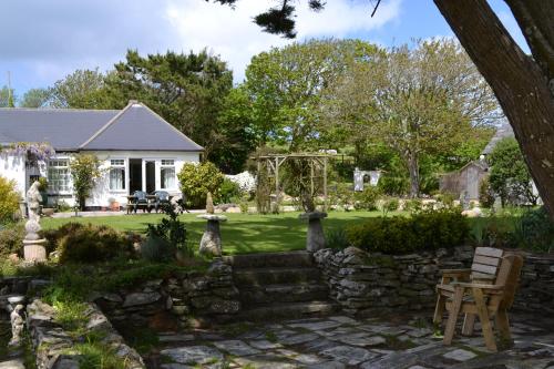 a house with a garden and a stone wall at Nanis in Crantock