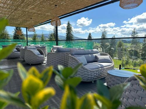 a patio with couches and a table and chairs at Domeniul CRIS Vatra Dornei in Vatra Dornei