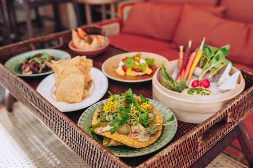 a tray with plates of food on a table at Ellery Beach House in Lidingö