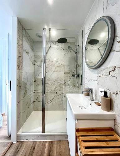 une salle de bain avec une douche, un lavabo et un miroir dans l'établissement Cocon Dacquois, à Dax