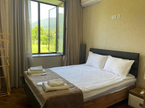 a bedroom with a bed with two towels on it at Lunisi Kvareli in Kvareli