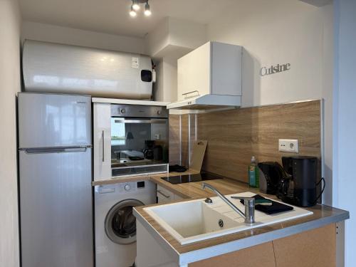 une cuisine avec un réfrigérateur, un évier et un lave-vaisselle dans l'établissement Studio autonomie et confort - Centre ville Boulogne Sur Mer - Baignoire et lave linge, à Boulogne-sur-Mer