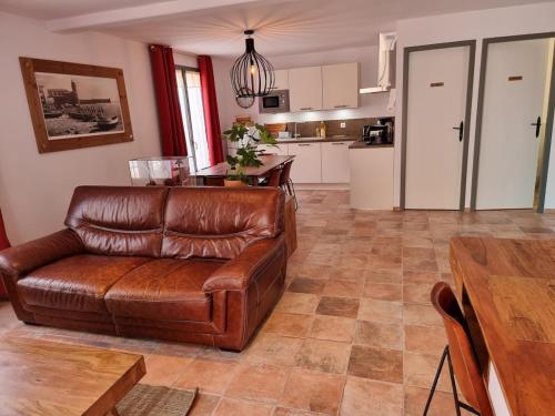 un salon avec un canapé en cuir et une table dans l'établissement Maison T3, quartier des peintres, calme et standing, patio privé, clim et wifi, à Collioure