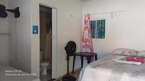 a bedroom with a bed and a toilet and a window at Brito Hospedagem in Barreirinhas