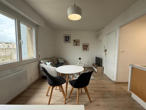 un salon avec une table et des chaises dans l'établissement Studio autonomie et confort - Centre ville Boulogne Sur Mer - Baignoire et lave linge, à Boulogne-sur-Mer