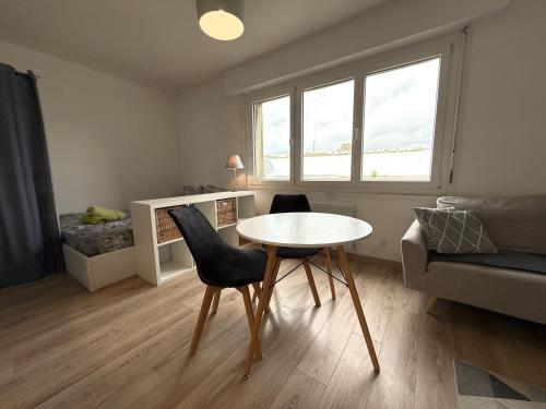 - un petit salon avec une table et des chaises dans l'établissement Studio autonomie et confort - Centre ville Boulogne Sur Mer - Baignoire et lave linge, à Boulogne-sur-Mer