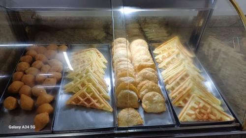 a display case filled with waffles and other pastries at Goldmen Business Criciúma in Criciúma