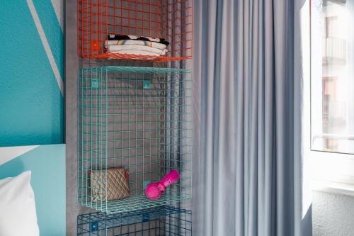 a wire bird cage in a bedroom with a window at ibis budget Hamburg St Pauli Messe - neu renoviert in Hamburg