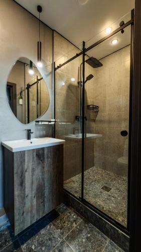 a bathroom with a shower and a sink and a mirror at Отель Авеню in Oral