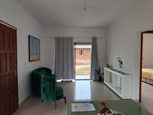 a living room with a green chair and a window at Bela Vista in Gravatal