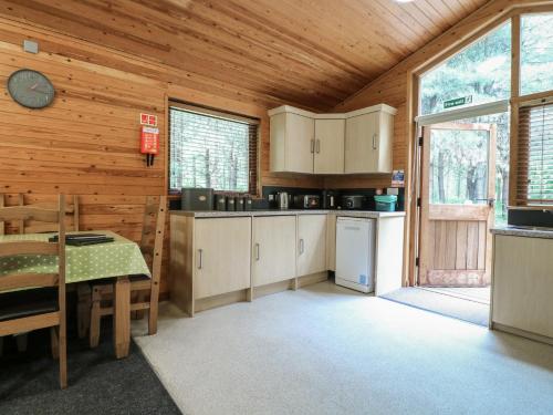 a kitchen with wooden walls and a large window at Rowan Lodge in Swadlincote