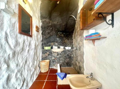 a small bathroom with a sink and a toilet at Casa Cueva con Vistas Panorámicas al Mar y BBQ in Pozo de las Calcosas