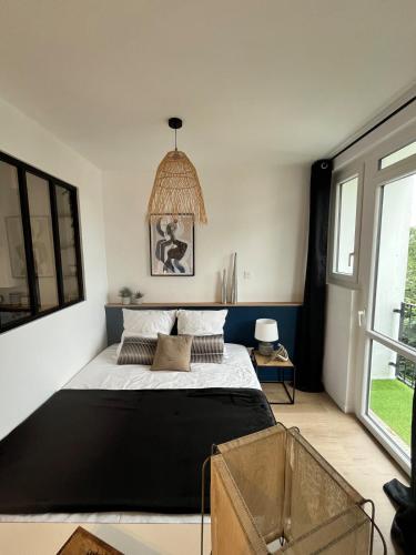 une chambre avec un lit et une grande fenêtre dans l'établissement L'Ancre Douce - Romantique et Cocooning, à Vannes