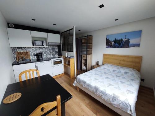 une chambre avec un lit et une table et une cuisine dans l'établissement Studio, à Chambéry