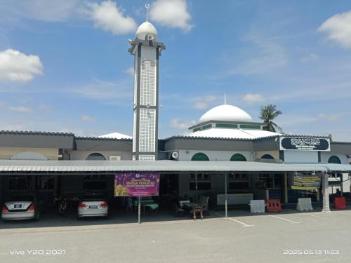 a large building with a clock tower and a parking lot at Homestay Masjid Seberang Marang in Marang