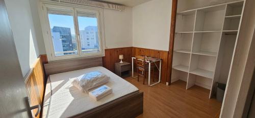 a small bedroom with a bed and a window at Location Meublée 8 Personnes - Proche Trentemoult in Rezé