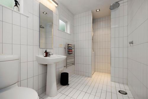 Iconic Villa in the Heart of Ponsonby في أوكلاند: حمام أبيض مع حوض ودش