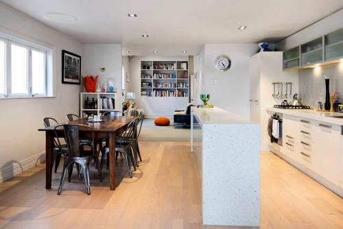 Iconic Villa in the Heart of Ponsonby في أوكلاند: مطبخ وغرفة طعام مع طاولة وكراسي