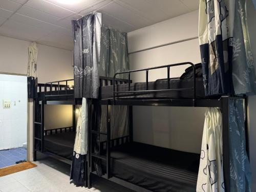 two bunk beds in a dorm room with a window at MaHar Hostel ChiangMai in Chiang Mai