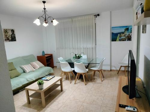a living room with a green couch and a table at Alojamiento las Dunas in Tabernas