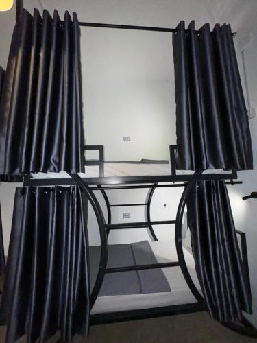a bed with black curtains in a room at Poolside Villa in Phnom Penh