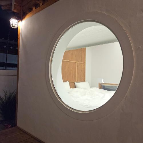 a circular mirror in a room with a bed at Wolha in Gyeongju