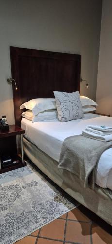 a bedroom with a large bed with a wooden headboard at Elegant Lodge & Conference Center in Pongola